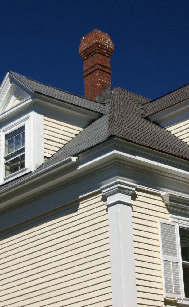 White house with chimney and blue sky